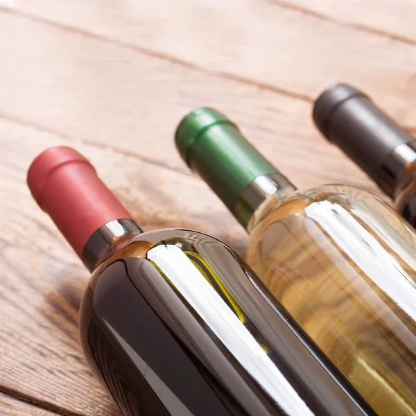 Wine bottles on wooden background — Stock Photo, Image
