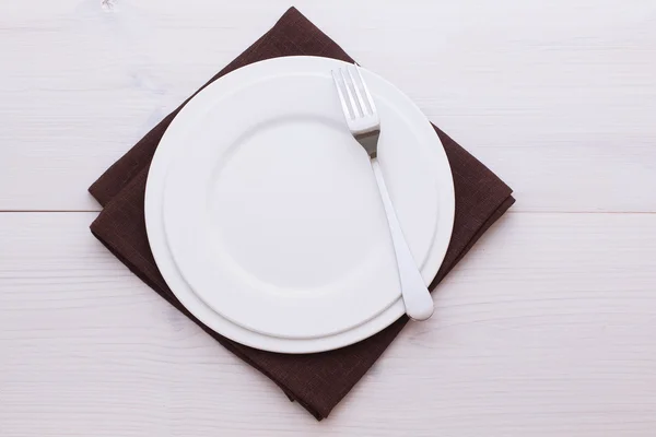 Placas vazias e toalha de mesa de talheres na mesa de madeira para o jantar . — Fotografia de Stock