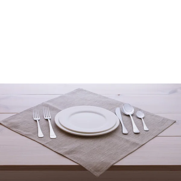 Empty plates and cutlery tablecloth on wooden table for dinner. — Stock Photo, Image