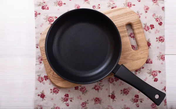 Leere Pfanne auf Holzdecktisch mit Tischdecke — Stockfoto