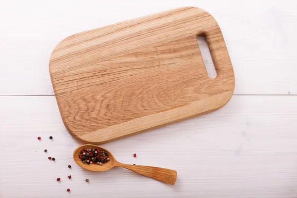 Lege snijplank, specerijen op witte houten tafel. Flat mock up — Stockfoto
