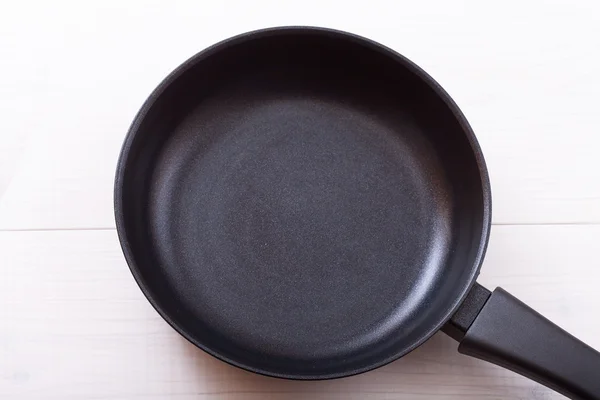 Empty pan on wooden deck table with tablecloth — Stock Photo, Image