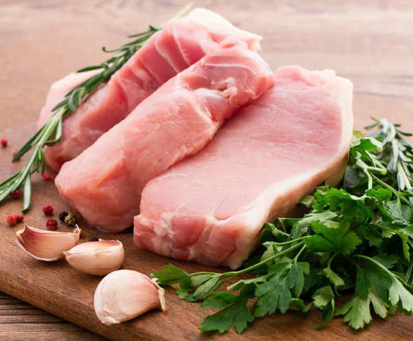 Rohes Schweinefleisch auf Holztisch — Stockfoto