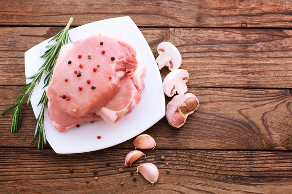 Syrové vepřové maso na dřevěný stůl — Stock fotografie