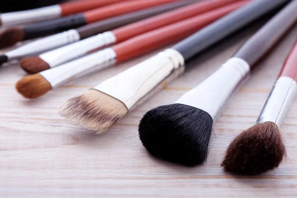 Escova de maquiagem profissional em fundo de madeira branca — Fotografia de Stock