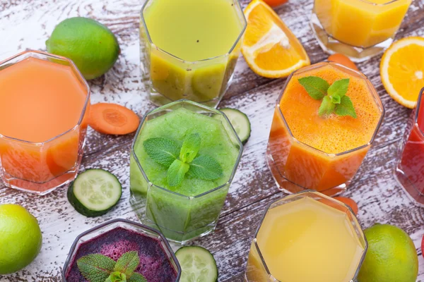Zöldség, friss gyümölcslevek keverjük össze a gyümölcs egészséges italok a fa asztal. — Stock Fotó
