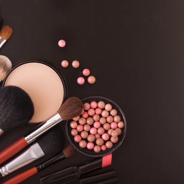 Divers produits de maquillage sur fond noir foncé avec copyspace — Photo