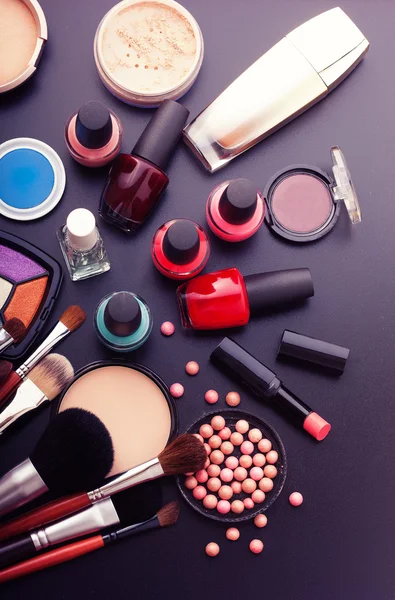 Různé výrobky make-up na tmavě černé pozadí s copyspace — Stock fotografie