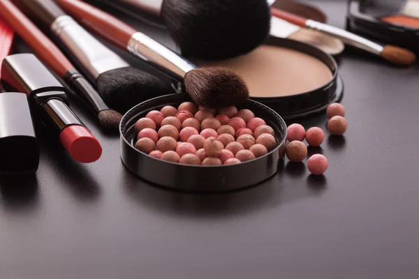 Různé výrobky make-up na tmavě černé pozadí s copyspace — Stock fotografie