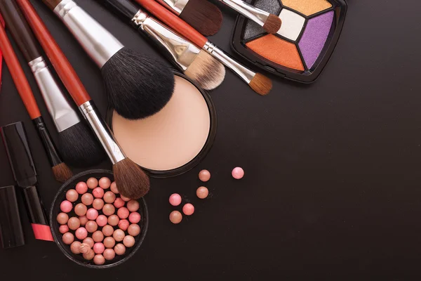 Verschiedene Make-up-Produkte auf dunkelschwarzem Hintergrund mit Copyspace — Stockfoto