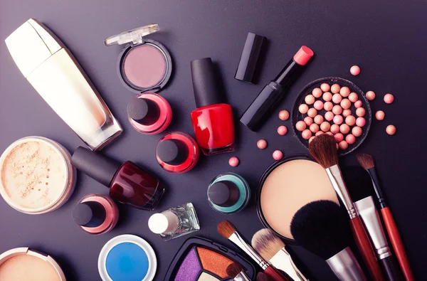 Divers produits de maquillage sur fond noir foncé avec copyspace — Photo