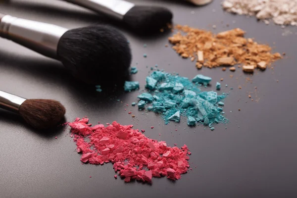 Brosses de maquillage sur fond avec poudre colorée . — Photo