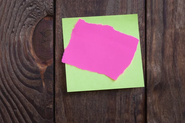 Різнокольорові паперові наклейки на дерев'яному фоні . — стокове фото