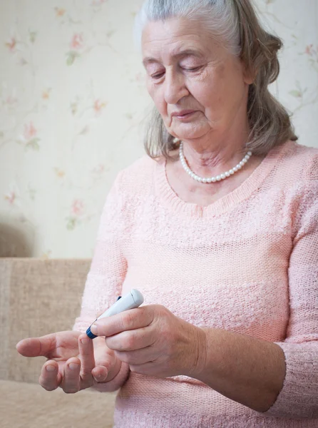 Bejaarde vrouw maakt testen hoge bloedsuikerspiegel. — Stockfoto