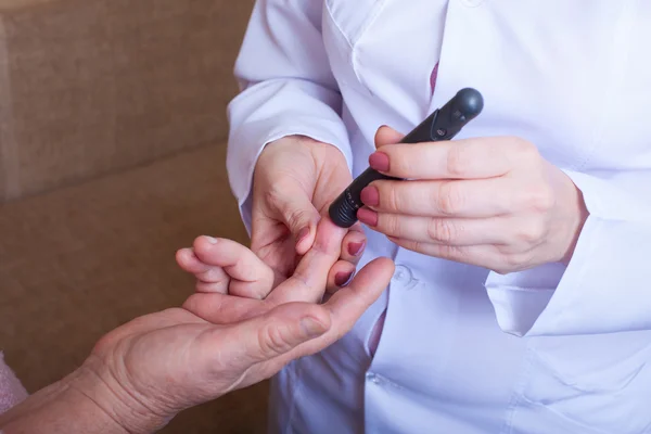 Nurse takes test for sugar in blood of elderly woman at home — Stock Photo, Image