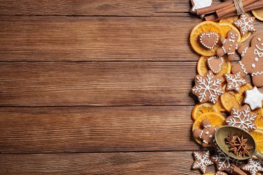 Noel pastası, zencefilli ekmek, kuru portakallar ve baharatlarla dekore edilmiş arkaplan olarak ahşap masa manzarası