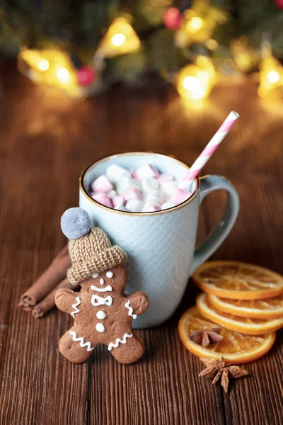一杯热巧克力和棉花糖放在木制桌子上 上面有姜饼人和圣诞装饰 图库图片