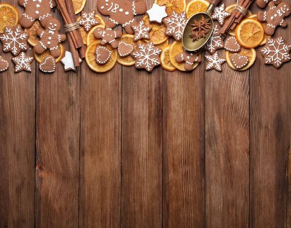以木制桌子为背景的顶视图 以圣诞糕点 生姜面包 干橙子和香料装饰复制空间 免版税图库图片