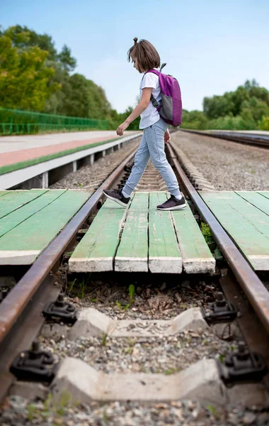 Tagsüber Über Die Bahngleise Aus Holz Schülerin Trägt Roller Und lizenzfreie Stockfotos