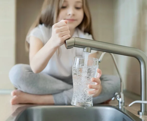 Little child open water tap. Kitchen faucet. Glass of clean water. Pouring fresh drink. Hydration. Healthy lifestyle. Good habit. Water quality check. World water monitoring day. Plastic free concept