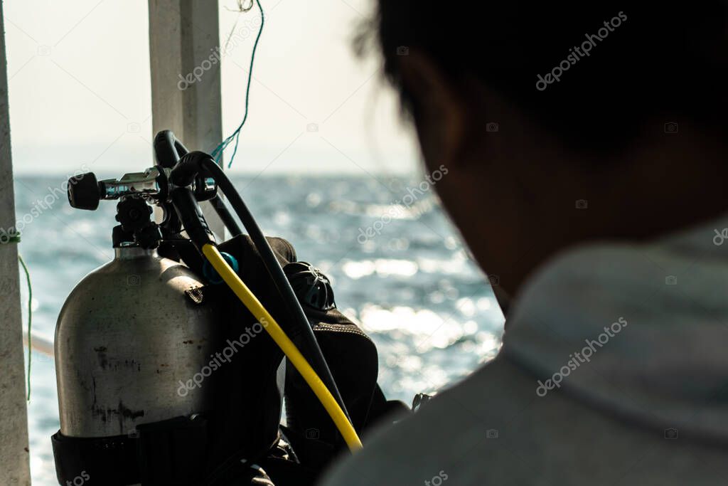 View of the faucet valve of a scuba diving oxygen tank over the shoulder of a person, Calventuras islands, Ngwesaung, Irrawaddy, Myanmar