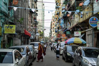 Yangon, Myanmar - 30 Aralık 2019: Central City 'deki diğer yayalarla dolu dar bir sokakta bir keşiş yürüyor