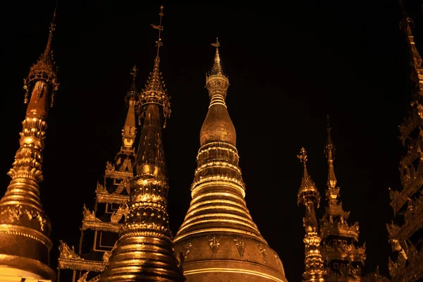 缅甸仰光 2019年12月30日 几座闪亮的金色塔楼的顶部 映衬着沙夫冈塔的漆黑夜空 — 图库照片