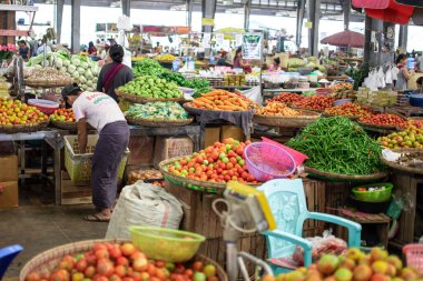 Birmanyalılar, Yangon, Myanmar yakınlarındaki yerel bir meyve ve sebze pazarını ziyaret ediyor.