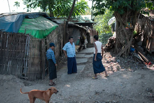 YANGON, MYANMAR - 31 ARALIK 2019: Geleneksel Longyi 'de üç yerli Burmalı tren geçerken sohbet ediyorlar