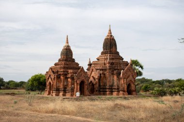 BAGAN, NYAUNG-U, MYANMAR - 3 HAZİRAN 2020: 2 eski tarihi tapınak pagoda açık bir çim tarlasında