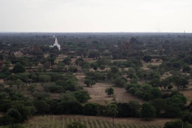 BAGAN, NYAUNG-U, MYANMAR - 3 HAZİRAN 2020: Bagan 'ın uçsuz bucaksız ovalarına tarihi tapınakları ve tarlalarıyla uzun Nan Myint kulesinden bakıyor