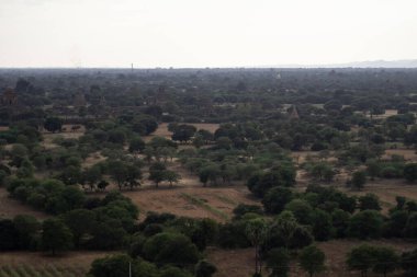 BAGAN, NYAUNG-U, MYANMAR - 3 HAZİRAN 2020: Bagan 'ın uçsuz bucaksız ovalarına tarihi tapınakları ve tarlalarıyla uzun Nan Myint kulesinden bakıyor