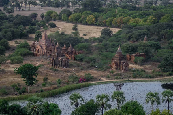 BAGAN, NYAUNG-U, MYANMAR - 3 HAZİRAN 2020: Uzun Nan Myint izleme kulesinin yanındaki birkaç eski tarihi ve dini tapınağa bakıyorum.