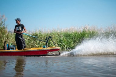 Shan State, Myanmar - 7 Ocak 2020: Longyi 'de yerel bir kaptan, Inle Gölü, Nyaung Shwe kanallarında yüzen bahçelerde geleneksel bir tekne kullanıyor.