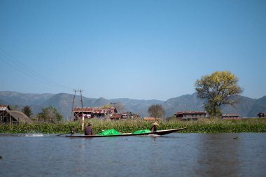 Inle Gölü, Nyaung Shwe, Shan Eyaleti, Myanmar - 7 Ocak 2020: Kanal boyunca yüzen bahçelerden ve binalardan geçen iki yerel taşıma