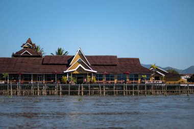 Inle Gölü, Nyaung Shwe, Shan State, Myanmar 'da nehir kenarındaki büyük sarı bir bina.