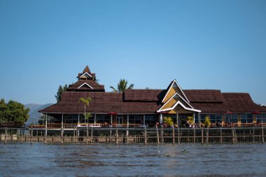Inle Gölü, Nyaung Shwe, Shan State, Myanmar 'da nehir kenarındaki büyük sarı bir bina.