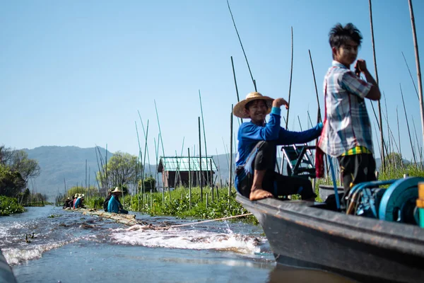 Shan State, Myanmar - 7 Ocak 2020: Yerel halk bambu üzerinde oturuyor ve Inle Gölü, Nyaung Shwe 'de bir teknenin sürüklediği bir nehirde yüzüyor.