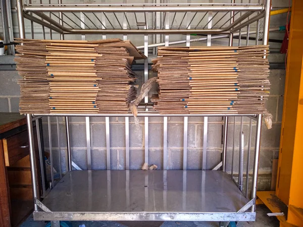 Geri dönüşüm için çelik bir rafa istiflenmiş karton. 