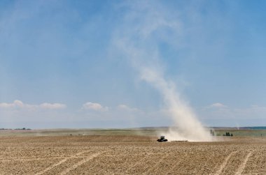 tarım traktörü kuru bir tarlayı sürüyor, kuraklık zamanları