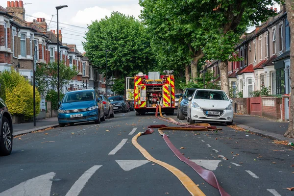 İngiltere, İngiltere 'de bir itfaiye aracı yangın söndürüldükten sonra sokağın ortasında kurumuş hortumlarıyla yangına katılıyor.
