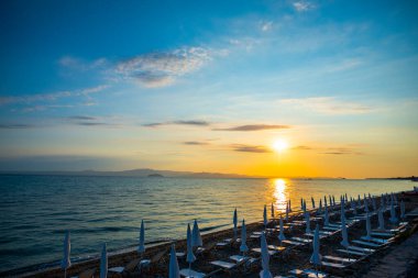 Sahil ve deniz manzarası, gün batımı ışığı ve güneş ışıkları. 