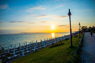 Sahil ve deniz manzarası, gün batımı ışığı ve güneş ışıkları. 