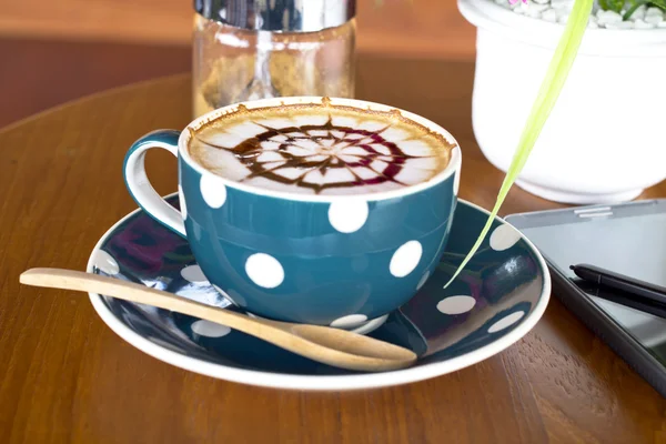 Koffiebeker en smartphone op een houten tafel — Stockfoto