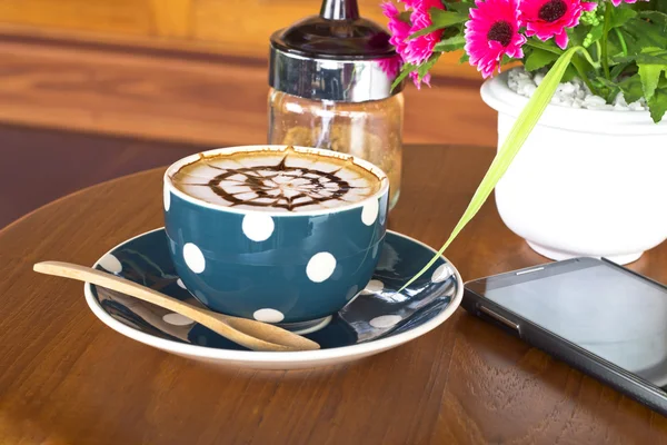 Koffiekopje op een houten tafel — Stockfoto