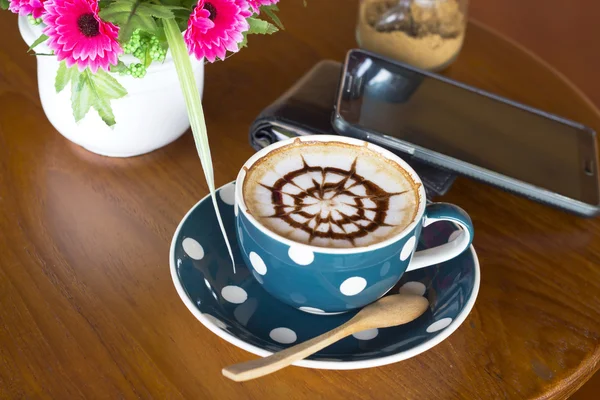Filiżanka kawy i smartfon na drewnianym stole — Zdjęcie stockowe