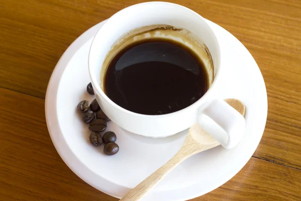 Šálek kávy na dřevěný stůl — Stock fotografie