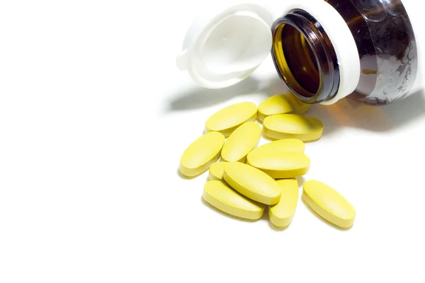 Vereinzelt. Gelbe Pillen auf Weiß — Stockfoto