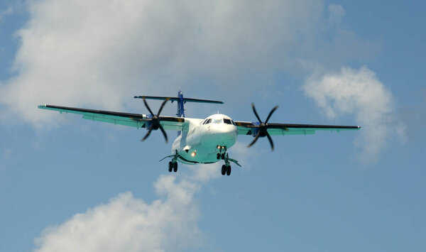 Пассажирский турбовинтовой самолет приближается к посадке