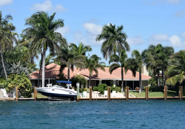 Waterfront mansion with boat and dock — Stock Photo, Image